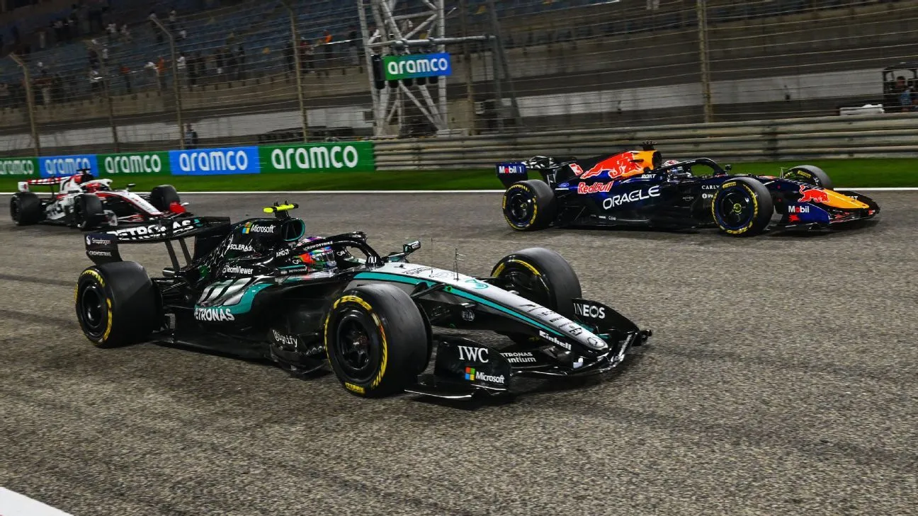 a mercedes leads a red bull through a floodlit corner